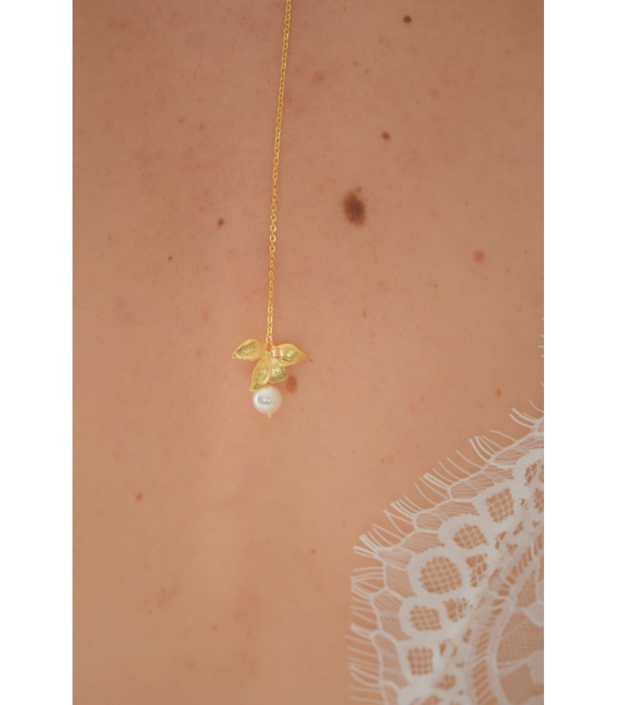 Pendentif de dos Nymphea pour la mariée avec fleur d'orchidée dorée et perle nacrée, montées sur fine chaine.