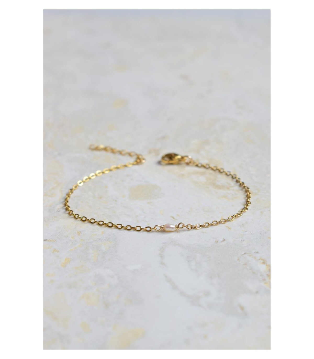 bracelet en acier doré avec une perle irrégulière toute petite